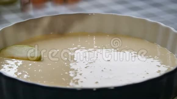 女人做苹果派厨师把苹果片放进烤盘里在烤盘的蛋糕面糊上切苹果视频的预览图