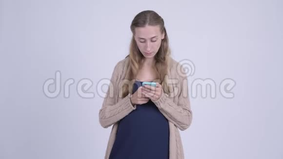 快乐的年轻孕妇一边思考一边打电话视频的预览图