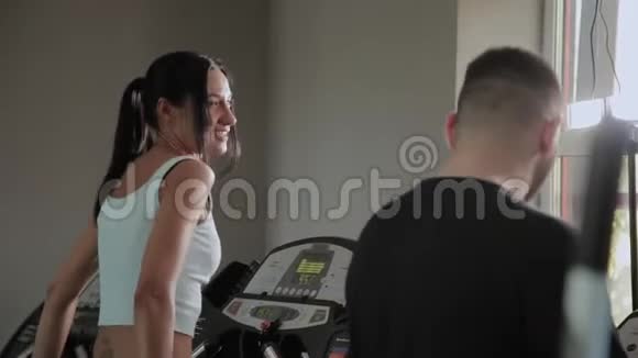 美丽的运动女性和超重的男性正在跑步机上训练视频的预览图