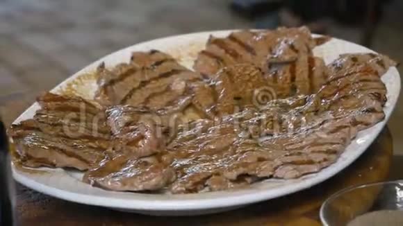 餐厅厨师用瓶子里的橄榄油为客人准备现成的肉类牛排视频的预览图