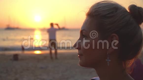 海滩上海边日落时平静的快乐女孩的特写肖像视频的预览图