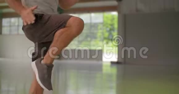 青年男子在健身运动中做高膝跳跃运动双腿细节Grunge工业城市视频的预览图