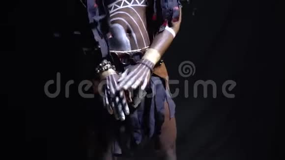 一个身穿白色图案和木制面具的巫师在黑色背景上跳舞动作缓慢视频的预览图