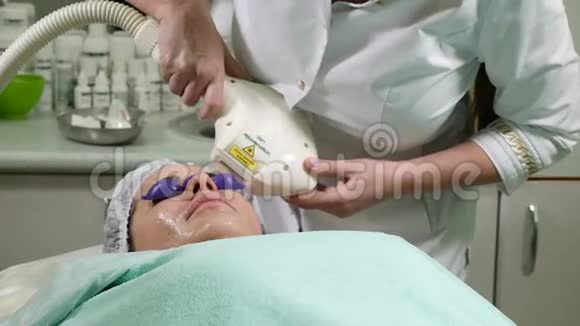 皮肤护理一位戴眼镜的女士在美容院接受照片修复手术美容师表演视频的预览图
