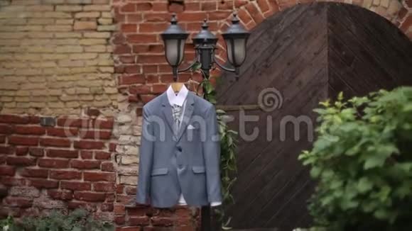 新郎婚礼前院子里挂着一件灰色夹克套装挂在衣架上视频的预览图