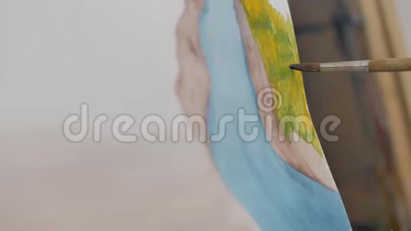 艺术家的手一位女艺术家用画笔绘制画布坐在画架上在画架上进行笔触视频的预览图