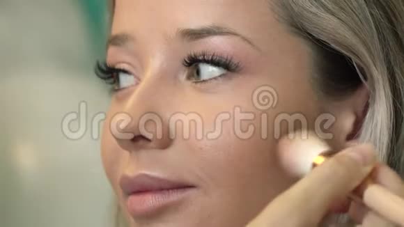 为一个绿眼睛的漂亮女孩化妆从事时尚美容行业的专业化妆师视频的预览图