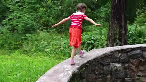小可爱的女孩爬上石头墙跑视频的预览图
