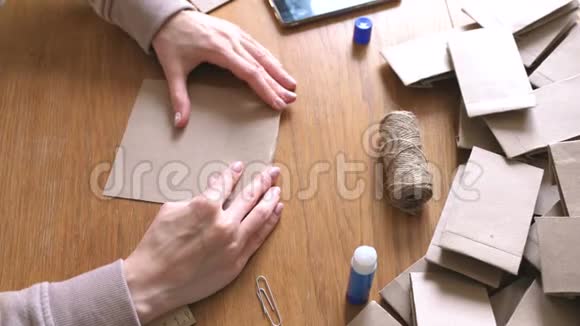 女人用牛皮纸做了一个纸袋用来做日历双手特写弯曲尺子视频的预览图