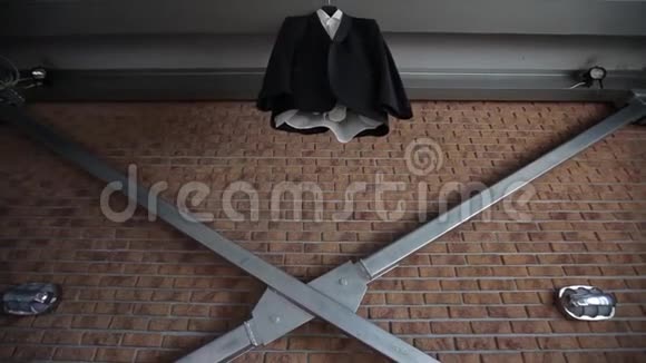 新郎结婚前一个男人的夹克和西装挂在一个靠近红砖墙衣架上视频的预览图