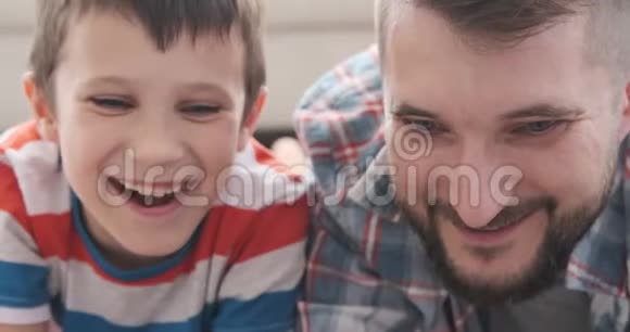 父亲和儿子在家看电影视频的预览图