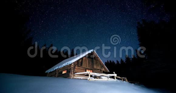 时间流逝美丽的木屋在冬天的森林里星空下视频的预览图