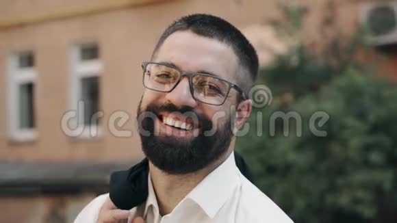 戴眼镜的胡子男看着相机在街上笑着视频的预览图