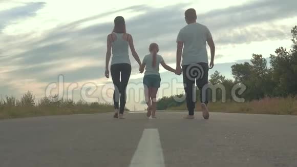 父亲和母亲带着孩子在农村上路旅游徒步和人的概念视频的预览图