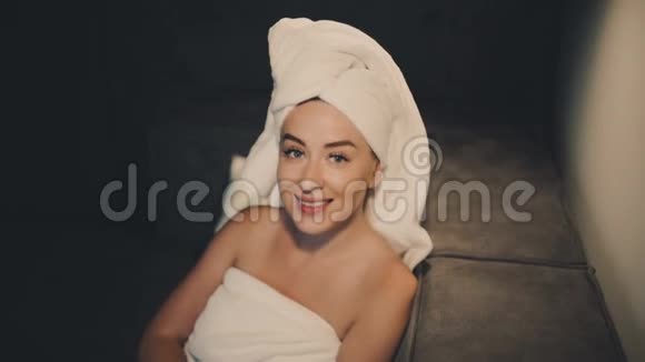 美女的肖像头上有一条毛巾她的头在动微笑着视频的预览图