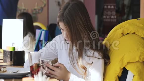 在咖啡馆里用智能手机的漂亮女孩斯洛文尼亚视频的预览图