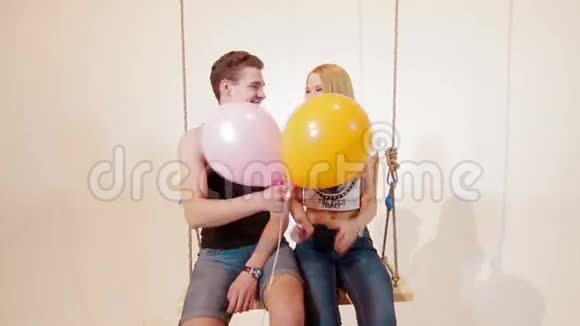 年轻人在秋千上给她女朋友气球视频的预览图