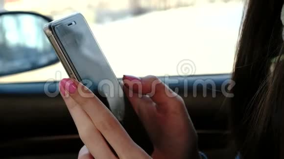 贴身女人她的手在车里发手机短信侧视视频的预览图