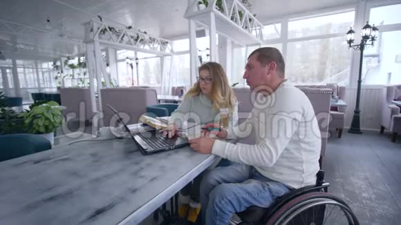 家庭教育中残疾聪明疼痛学生轮椅上的成年男子和家庭教师女性的教育课程视频的预览图