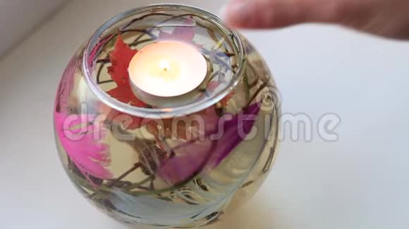 女人手把蜡烛放在装有水和装饰的瓶子里视频的预览图