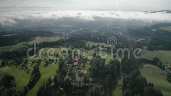 空中的巴伐利亚阿尔卑斯山高尔夫球场布隆伯格山早晨的无人机在天空中用云层拍摄视频的预览图