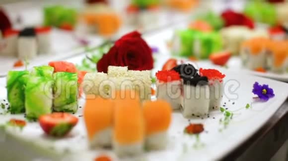 在白色盘子上用鲜花装饰各种美味寿司视频的预览图