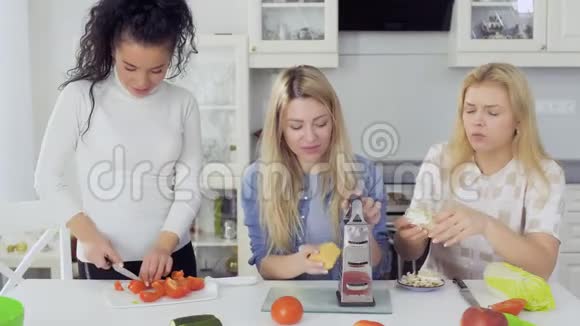 美丽的三个白人女人一起在厨房准备新鲜沙拉视频的预览图