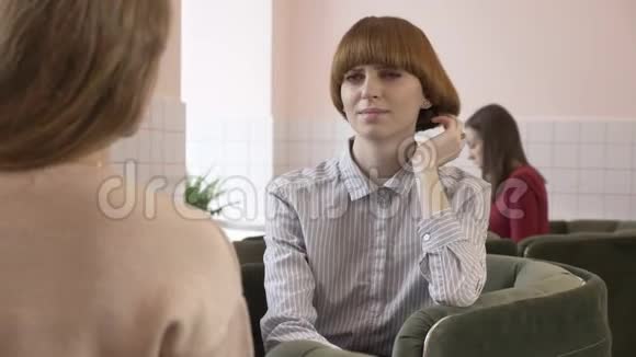 三个白种人年轻女孩坐在咖啡馆里微笑交谈对话有趣的故事情感视频的预览图