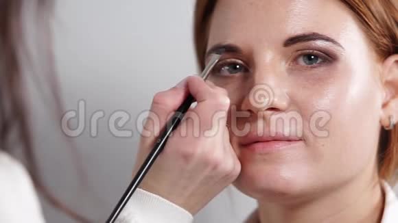 一个化妆师用铅笔画眉的特写镜头视频的预览图