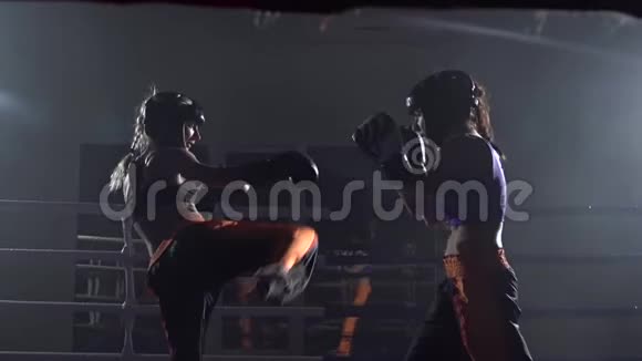 在黑暗的空间里两个女孩在拳击场上打斗慢动作视频的预览图