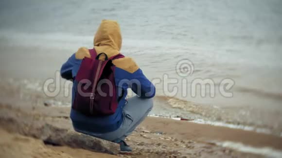 海滩上背着旅游背包的男人视频的预览图