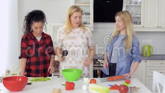 年轻女孩做沙拉把新鲜的切菜混合在碗里视频的预览图