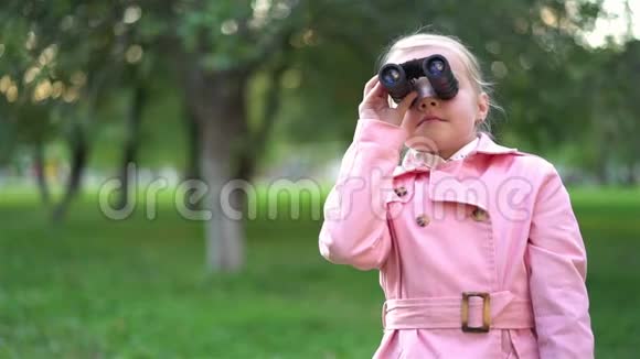 在公园里用望远镜看可爱的粉色小女孩视频的预览图
