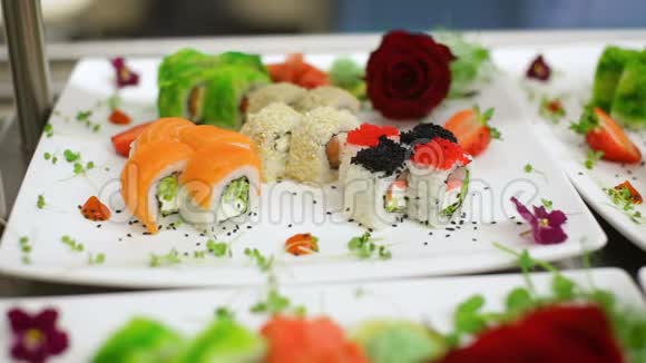 装饰着浪漫玫瑰和绿色植物的各种寿司的全景视频的预览图