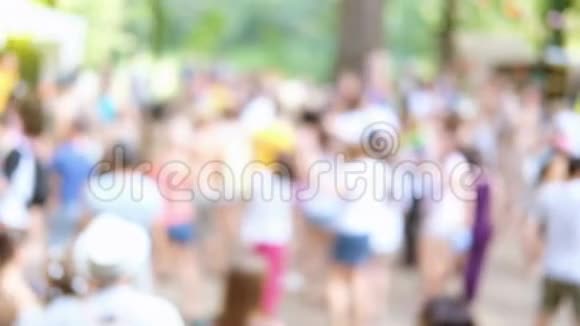 户外夏季派对背景模糊人们穿着五颜六色的衣服在森林公园户外跳舞视频的预览图