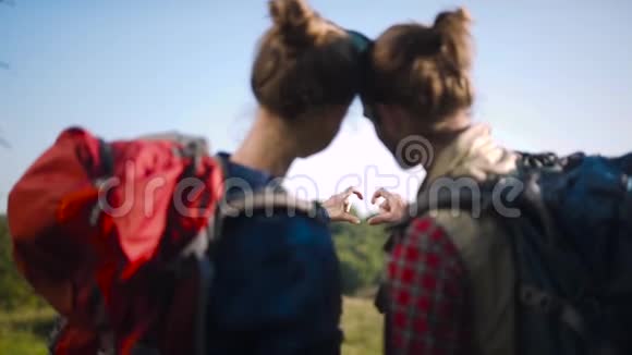 旅游情侣在爱旅游用手做心形标志视频的预览图