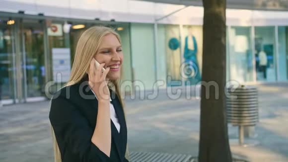 兴高采烈的女经理挥手致意一个穿着西装的金发女商人坐在长凳上用手挥手视频的预览图