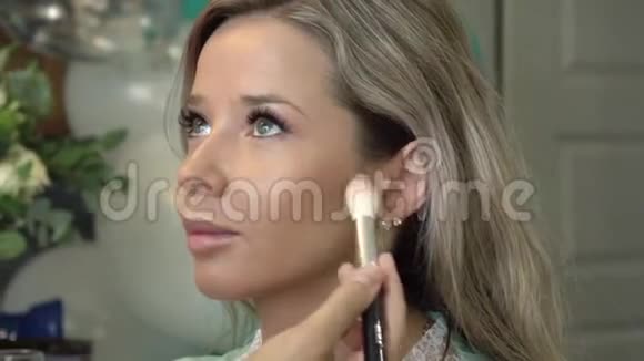 为一个绿眼睛的漂亮女孩化妆从事时尚美容行业的专业化妆师视频的预览图