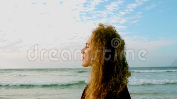 体贴的白种人年轻女人站在阳光下的海滩上视频的预览图