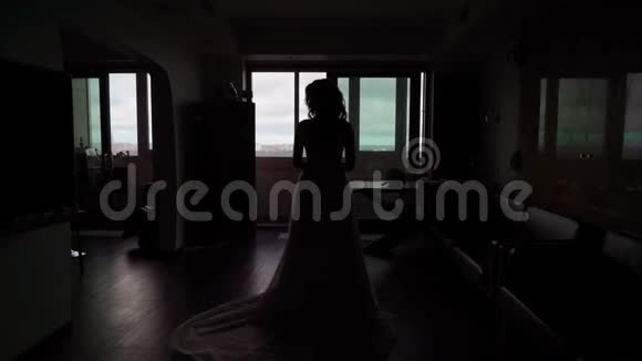 年轻女子穿着婚纱住在靠近窗户的房间里视频的预览图