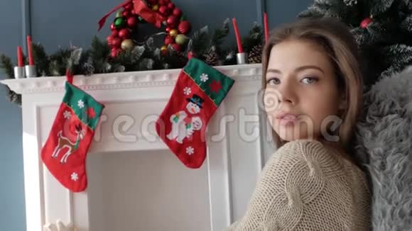 坐在壁炉旁的漂亮女孩新年视频的预览图