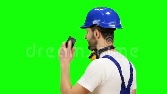 戴着蓝色头盔的工程师在电话里讲话竖起大拇指绿色屏幕视频的预览图