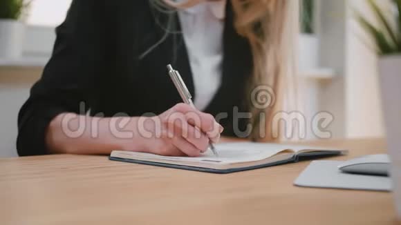 漂亮的金发女郎套装坐在书桌前用笔在记事本上写字翻页抽出床单视频的预览图