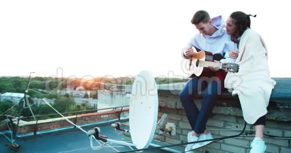 浪漫的气氛美丽的幸福夫妇坐在屋顶上帅哥在弹吉他很可爱视频的预览图