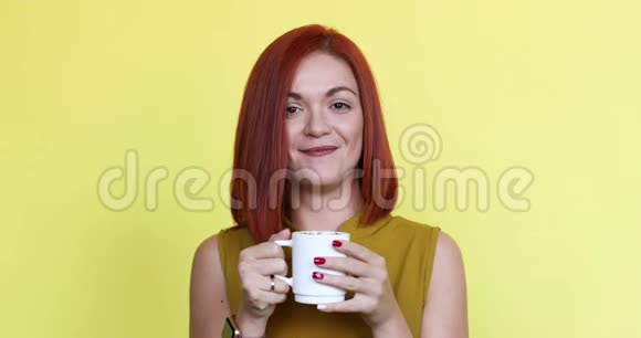 幸福的红发女人带着杯咖啡或茶视频的预览图