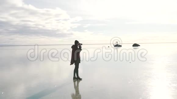旅游女孩为冰冻湖拍照视频的预览图