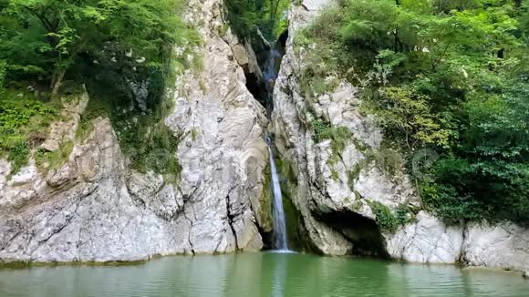 一条高高的瀑布从悬崖上跌入清澈的湖面俄罗斯索契视频的预览图