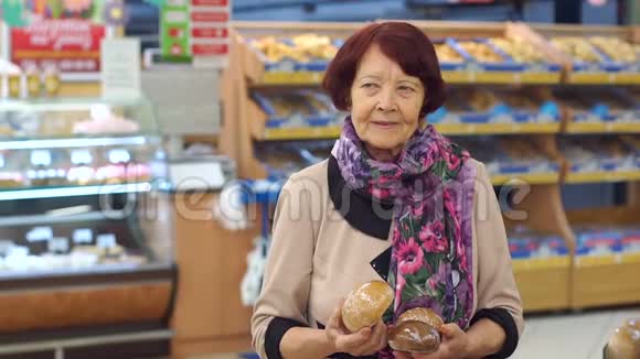一位脸上有皱纹的老妇人在超市里挑选产品视频的预览图