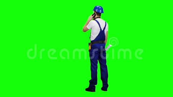工程师背对着图纸站在那里打电话绿色屏幕视频的预览图