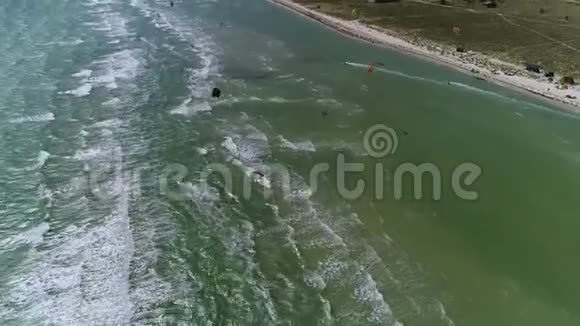 空中射击海上和海滩人们管理着明亮的训练风筝视频的预览图